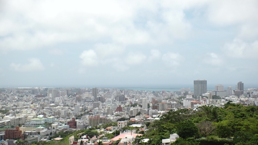 NAHA, OKINAWA, JAPAN - AUGUST 2021 : Aerial high angle wide view of Naha city in daytime. Cityscape of downtown area and sunny blue sky. Summer holiday, vacation and travel concept video. | Shutterstock HD Video #1091760853