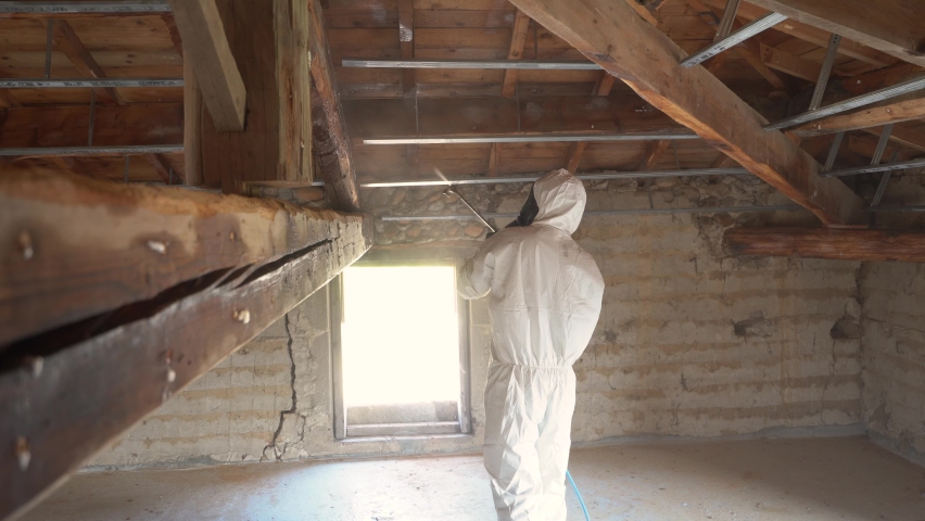 Pest Control Exterminator Treating Termites At The Woodframe Of A Structure. Medium Shot Royalty-Free Stock Footage #1091762625
