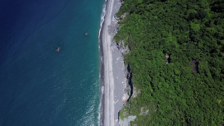 Tropical beach covered in fallen boulders from gradual cliff-side erosion on the Eastern coast of Taiwan - Gradual Gimbal tilt up