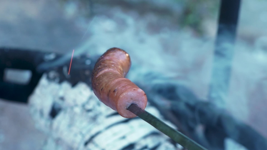 Sausage on a spit over a campfire
