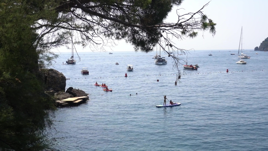 Europe, Italy , Liguria , Santa Margherita - Amazing beach and seacoast landscape in Paraggi, small marine bay with blue-green sea  near Cinque Terre and Portofino - people go canoeing | Shutterstock HD Video #1091767633