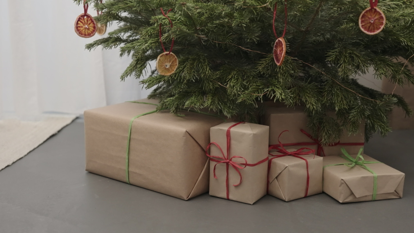 Handheld backward shot of christmas tree with present boxes indoor with warm light | Shutterstock HD Video #1091771383