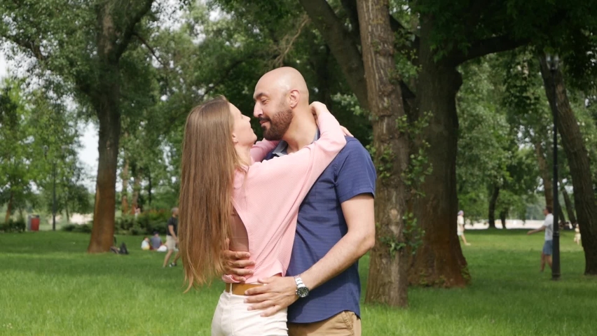 Closeup sensual couple dancing in slow motion at park. Romantic man and woman moving in dance at date outdoors. Portrait of happy people spending time at summer park weekend.