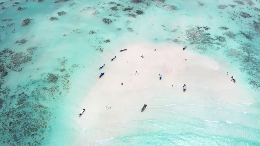 4K flying drone footage of boats on white sandbank coast with beautiful transparent rippled waves washing coral reefs atoll. Mnemba island, Zanzibar, Tanzania.Traveling in innocent Nature concept. | Shutterstock HD Video #1091773837