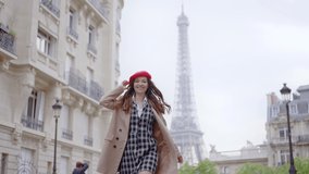 Cinematic footage of a young woman wearing fashionable clothes having fun in Paris at the eiffel tower park and streets. Concept about european tourism and travels to the capital cities