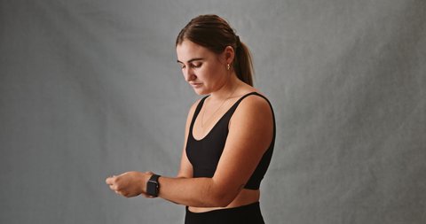 Young attractive Caucasian female adjusting her smartwatch strap