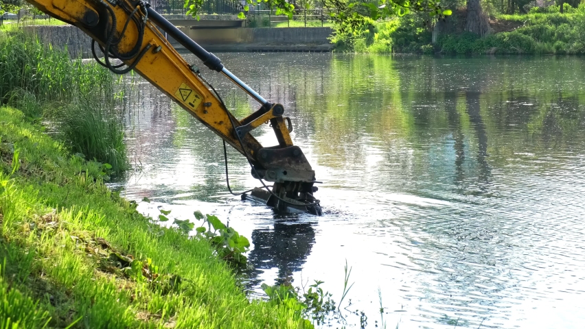 Industrial Heavy Duty Excavator Dredging River Bottom Removing Stincky Silt Mud Slime and Seaweed Wrack Royalty-Free Stock Footage #1091785791