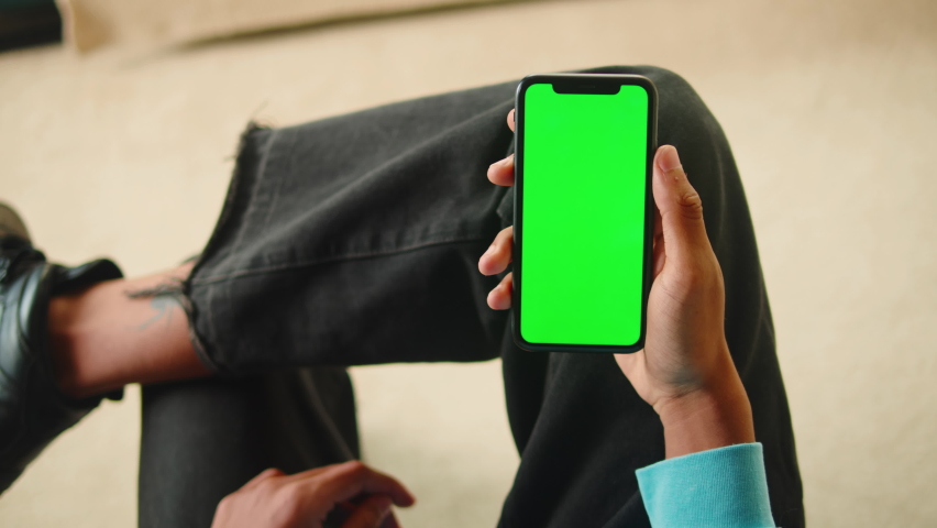 African American man using smartphone with chroma key close-up. Young guy holding mobile phone with green screen, teenager surfing the internet, watching video.  | Shutterstock HD Video #1091788253