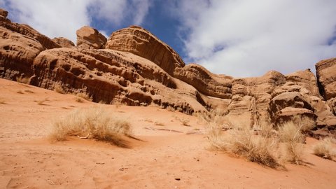 Rocky formations and mountains in sandy desert, blue sky above, typical scenery in Wadi Rum, Jordan