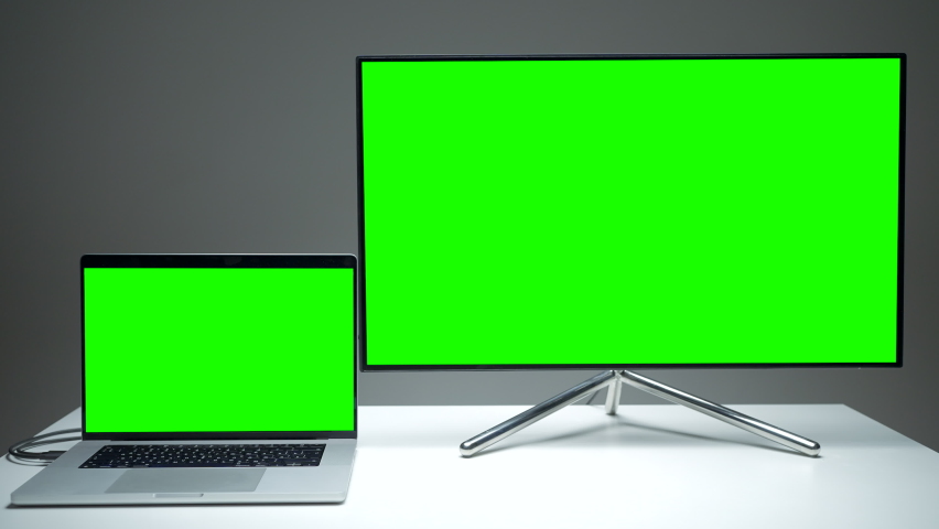 New TV models. Action.A small laptop that is comfortable to use and a large plasma TV with green screens. | Shutterstock HD Video #1091795355