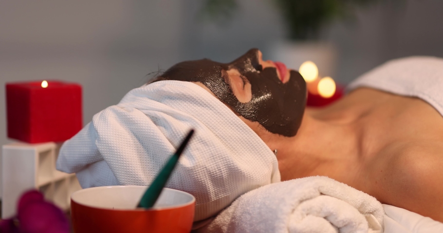 Beautiful woman with mask on face in beauty salon