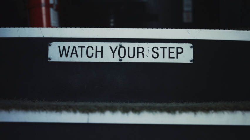 Watch your step warning sign school bus for children attentiveness safety closeup. Metal plate with inscription on stairway students transport. View of open schoolbus entrance with stairs inside cabin | Shutterstock HD Video #1091809661