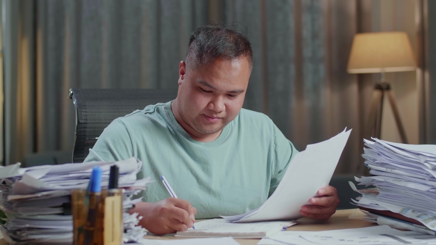 Close Up Of Smiling Fat Asian Man Enjoys Working With Documents At The Office
 | Shutterstock HD Video #1091813675