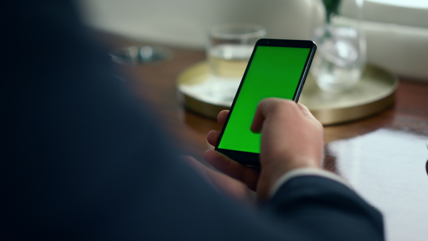 Man hand scrolling green smartphone screen closeup. Businessman using chroma key phone checking social media reading news in airplane. Unrecognized manager holding mockup cellphone browsing internet | Shutterstock HD Video #1091818681