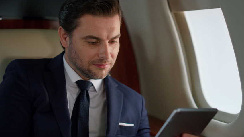 Successful manager tapping tablet in plane closeup. Focused ceo using computer checking online report in business class. Confident european businessman touch digital pad in jet. Corporate trip concept Royalty-Free Stock Footage #1091818717
