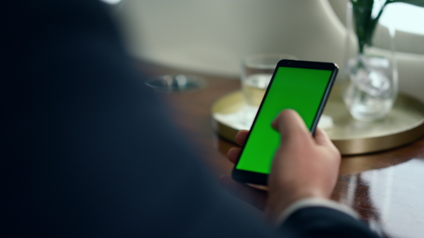 Businessman hand swiping green smartphone screen closeup. Man use mockup device on airplane travel. Unrecognized successful man touching chroma key phone. Passenger reading news checking social media | Shutterstock HD Video #1091818753