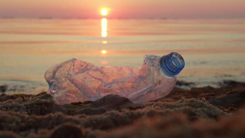 Man's hand in gloves collects empty plastic bottles on the seashore. Volunteer collects garbage in the sea. Clean planet Earth, collect garbage, avoid pollution. Ecological problem. Royalty-Free Stock Footage #1091821953