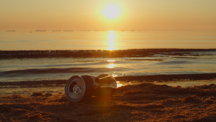 Volunteer cleans up a dirty beach from plastic bottles and various garbage on the seashore to collect garbage early in the morning at sunrise. Children and adults care about the environment. Royalty-Free Stock Footage #1091822085