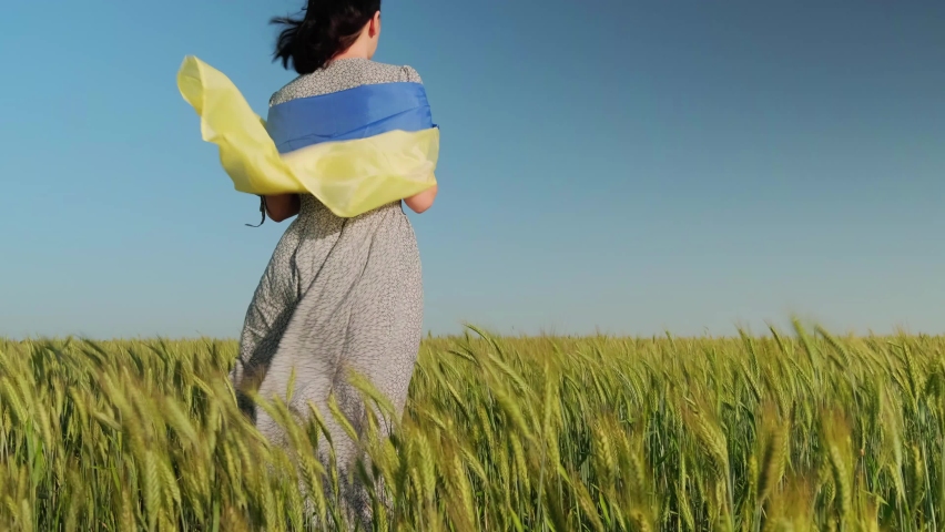 Young woman holding Ukrainian flag as a simbol of freedom. Support for Ukraine. Stop War in Ukraine.
