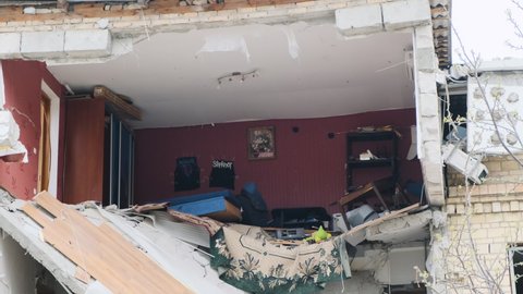 Irpin, Ukraine, april 2022: House without wall, furniture in residential apartment, wall destroyed. Destroyed house, war in Ukraine, consequences of shelling.