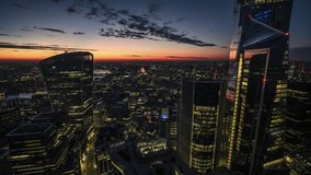 Establishing Aerial View Shot of London UK, Skyscrapers in City of London, St Paul's Cathedral in background, United Kingdom, colorful sky, early evening, pull back reveal