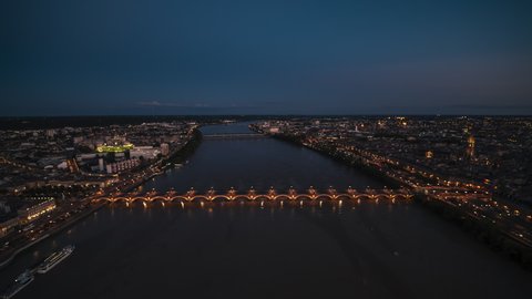 Establishing Aerial View Shot of Bordeaux Fr, world capital of wine, Nouvelle-Aquitaine, France at night evening, Stone bridge, Pont de Pierre