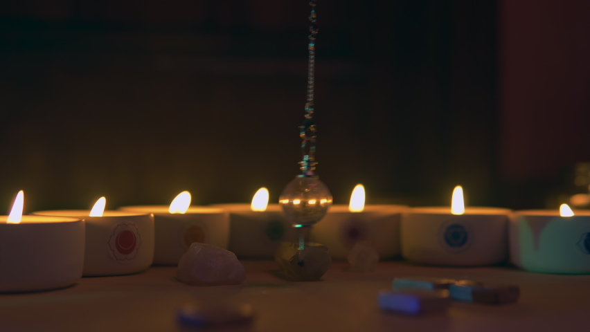 Fate prediction with candles and pendulum in dark space. | Shutterstock HD Video #1091850239
