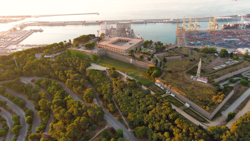 Aerial drone view of Barcelona, Catalonia, Spain. Montjuic Castle at sunrise, a lot of greenery, seaport on the background. Ancient fortification, a well-known landmark