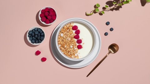 Smoothie bowls with granola, blueberries and raspberries on a pink background. Healthy breakfast step by step - Stop Motion Animation Stock Video