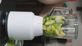 Vertical video. Pregnant Woman Preparing Green Healthy Smoothie with Blender in the Kitchen. Healthy Lifestyle and Nutrition for Expectant Mother 