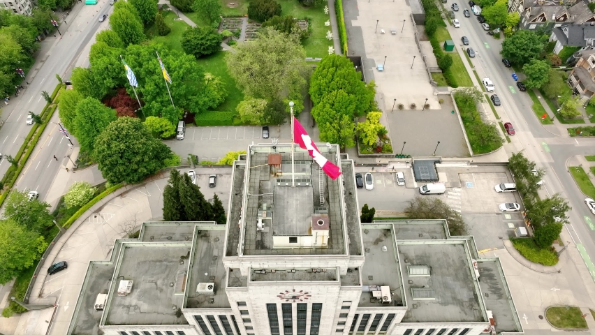 Vancouver Town Hall With Canadian Flag On Its Rooftop At Daytime In Vancouver, BC, Canada. - aerial tilt up