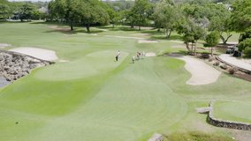 Golf club field at La Romana in Dominican Republic with cart and playing golfers. Aerial drone view
