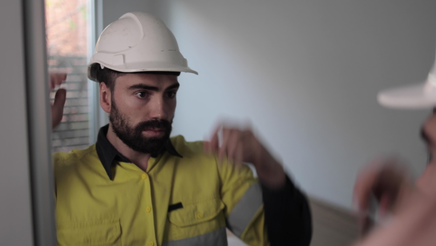 Medium Close Up of young construction worker getting dressed in morning before work. 