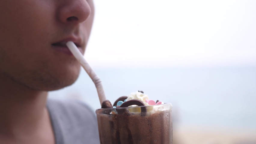 Man drinking cocoa with tasty cream,ice cream and chocolate. Summer and sugar concept. Close up | Shutterstock HD Video #1091859181