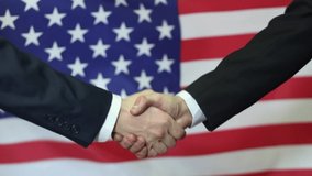 American business partners shaking hands on the background of the American flag.
 - Powered by Shutterstock - Get 15% off with code: PIKWIZARD15