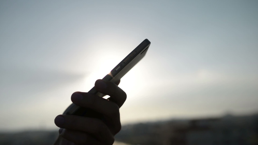 Texting on Smartphone during Sunset
