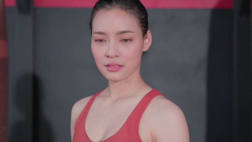 Portrait of Beautiful asian young woman cross arm look at camera with happy smile face. Fitness athlete beautiful girl wearing sportswear posing in gym. Healthy lifestyle concept.