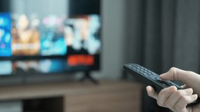 women hand holding the TV remote control and turn off smart tv. Channel surfing, focused on the hand and remote control. Internet TV at living room on holiday on sofa