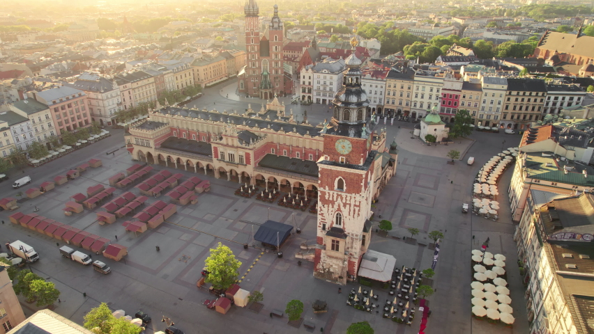 Main Market square or Rynek Glowny with a Town Hall, Sukiennice and St. Mary's Basilica church at sunrise in Krakow, Poland. Aerial view on the central square of Krakow in morning soft sunlight Royalty-Free Stock Footage #1091871549