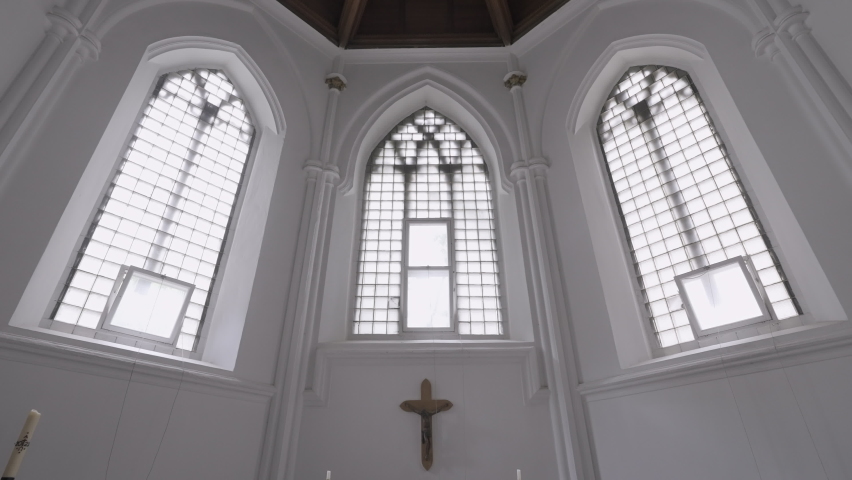 View inside of a white chapel with the cross crucifixion on the wall. Action. Concept of architecture and religion.