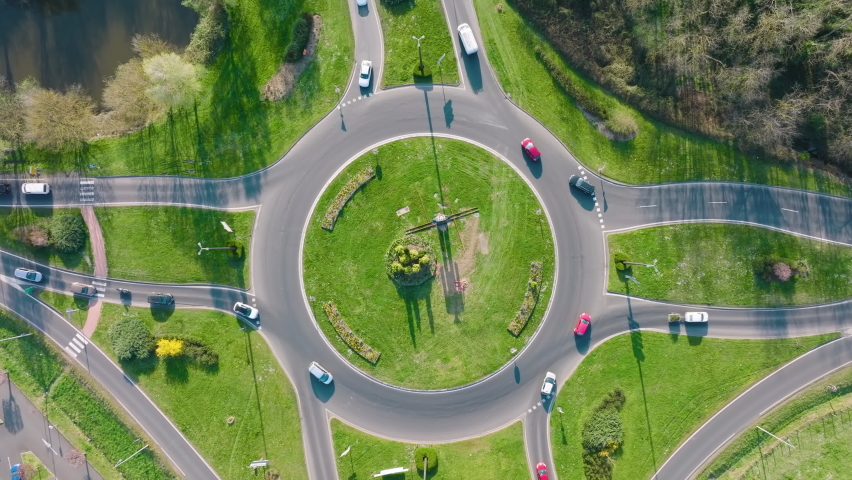 Aerial view of road roundabout intersection with fast moving heavy traffic. Urban circular transportation crossroads Royalty-Free Stock Footage #1091887603