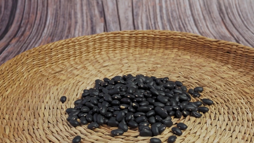 Brown bowl full of dry black beans. Healthy eating and vegetarian concept.