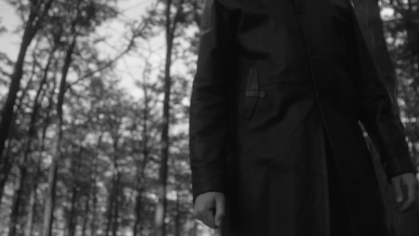 A hand of unrecognizable person in dark clothes throwing the first handful of earth into the grave against cemetery with trees. Tall unrecognizable man on funeral. Slow motion 200 fps Black and white Royalty-Free Stock Footage #1091889725