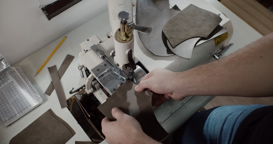 Top view of tailor thinning leather piece with leather skiving machine passing for making shoes in workshop background, slow motion 4k | Shutterstock HD Video #1091895653