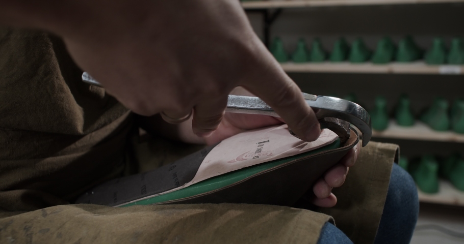Close up view of tailor nailing and fixing blank for shoes in private leather craftshop with pliers in slow motion 4k resolution | Shutterstock HD Video #1091895661