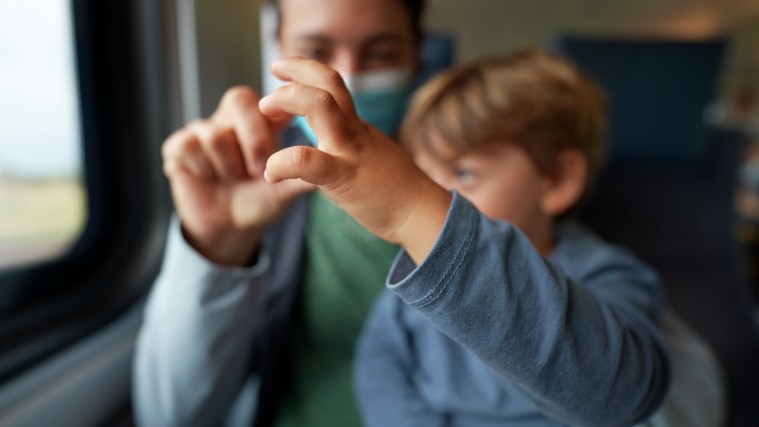 Mother and child hands together playing and bonding while traveling by train