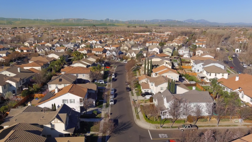 Aerial view flying above new housing development neighbourhood rooftops in Central valley of California | Shutterstock HD Video #1091905039