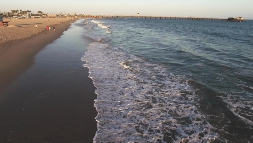 Drone footage of Seal Beach in Orange County California with ocean waves crashing into the sand