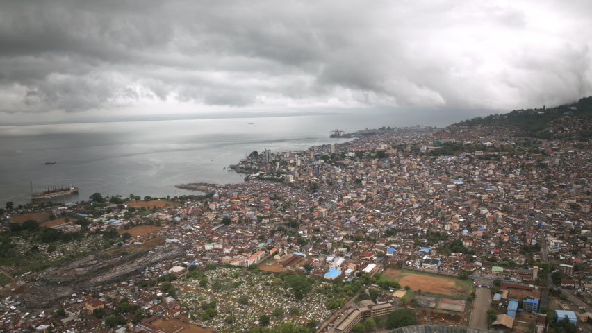Aerial hyperlapse of the downtown of Freetown, Sierra Leone with storm clouds in the background.