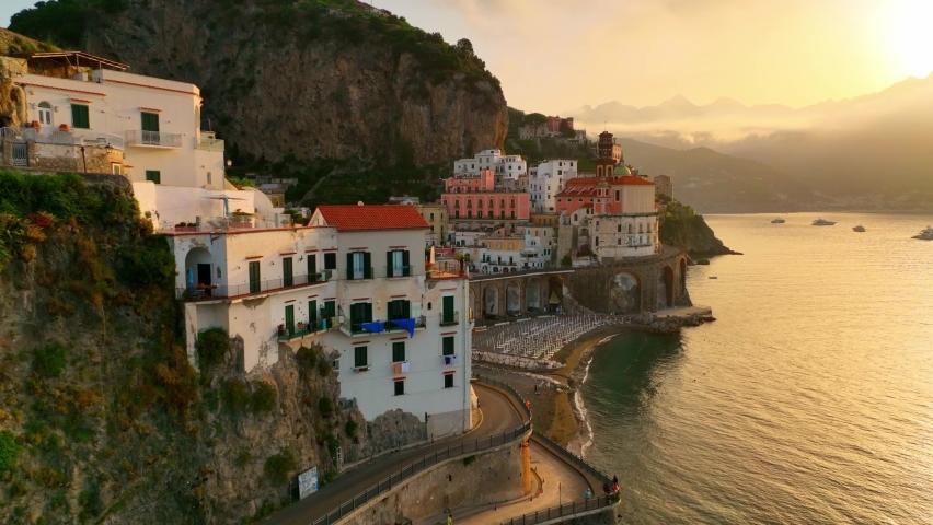 Sunrise at the Amalfi coast, aerial view of the coastal town of Amalfi and Atrani in Italy, famous seaside mediterranean town in Campagna, Italy, seacoast near Naples . High quality 4k footage